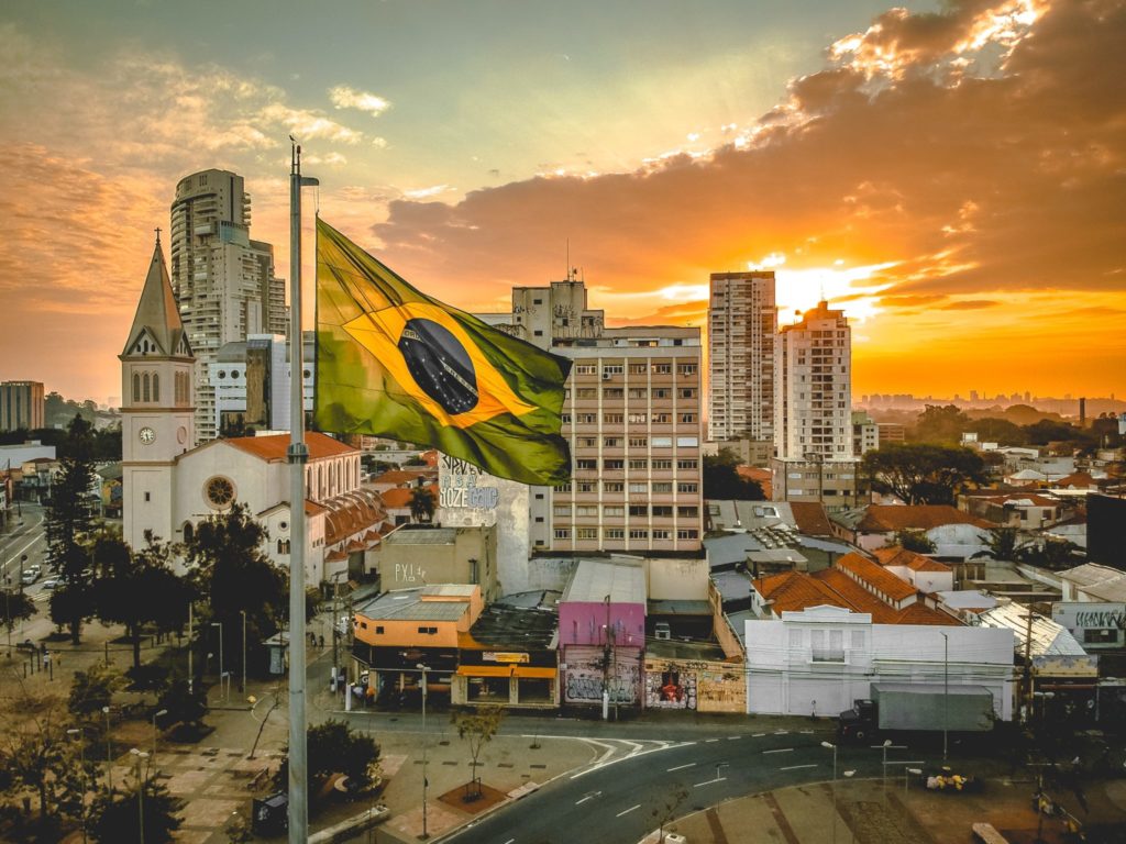 Brazilian flag with high rise buildings in the background